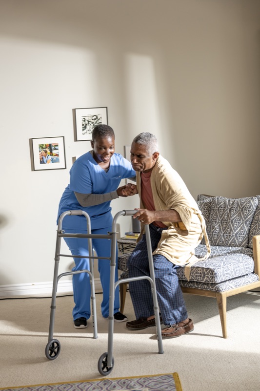 Caregiver helping senior with walker